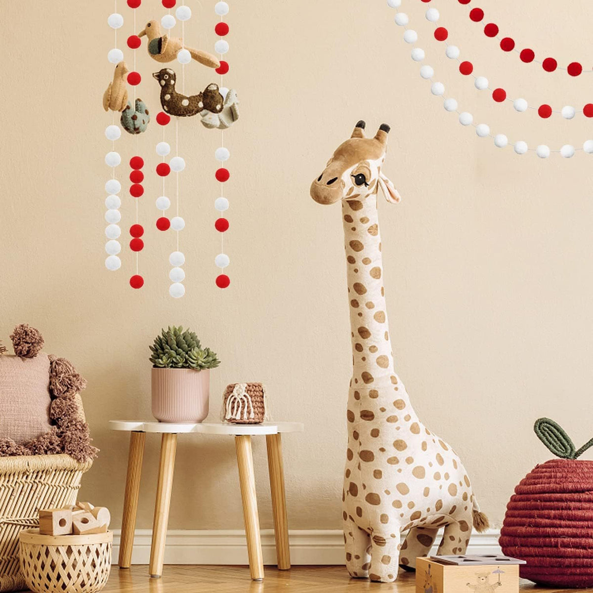 Red felt ball garland hung in a nursery